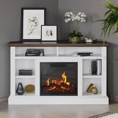 a living room with a fire place and pictures on the wall