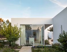 a white house with glass walls and wooden walkway