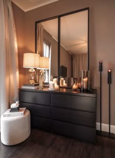 a dresser with candles on it and a large mirror