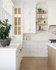 a large kitchen with white cabinets and wood flooring is seen in this image from the front view