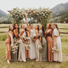 a group of women standing next to each other in front of a lush green field