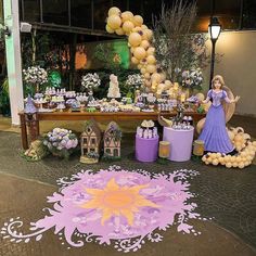 a table topped with lots of desserts and balloons in the shape of princesses