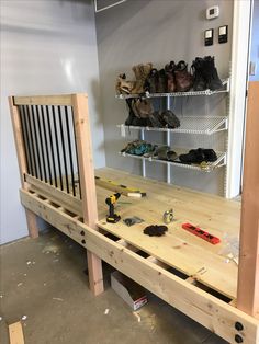 a wooden bench with shoes and tools on it in front of a wall filled with shelves