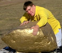 a man is leaning over a large rock