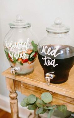 two glass jars filled with food sitting on top of a wooden table next to each other