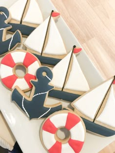 some decorated cookies are sitting on a plate with boats and life preservers in the background