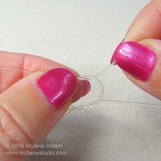 a person is holding a piece of wire with pink nail polish on it and there are two wires attached to them