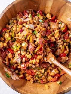 a wooden bowl filled with corn and vegetables