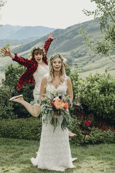 two brides are jumping in the air with their arms spread out and flowers on their heads