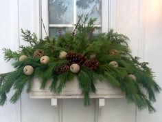 a window box filled with pine cones and greenery