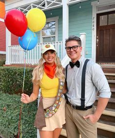 a man and woman posing for a photo with balloons in front of a house on a sunny day