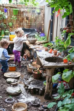 Children playing in an outdoor mud kitchen with various utensils and plants. Outside Mud Kitchen, Kids Outdoor Kitchen, Mud Kitchen Activities, Mud Kitchen Accessories, Mud Kitchen Ideas, Kitchen Play Area, Kitchen Birthday Party, Outdoor Mud Kitchen, Diy Ideas For Kids