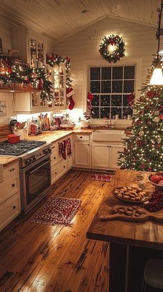 a christmas tree is in the middle of a kitchen decorated with lights and wreaths