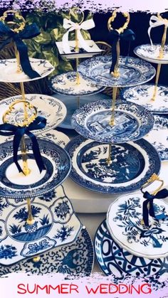 blue and white plates are stacked on top of each other, with gold stands in the middle