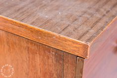 a close up of a wooden cabinet with peeling paint on the top and bottom part