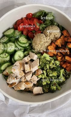 a white bowl filled with lots of different types of food on top of a table