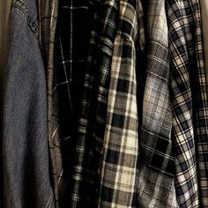 several plaid shirts hanging on a clothes rack