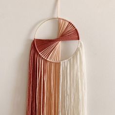 a wall hanging made out of yarn and string with a circular circle on the top