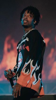 a man with dreadlocks standing in front of a screen