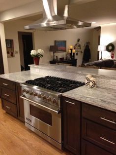 a kitchen with an oven, stove and counter top in the middle of the room