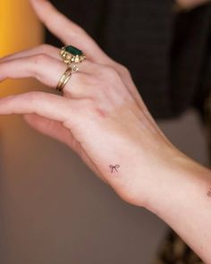 a woman's hand with a small tattoo on her left wrist and an arrow in the middle