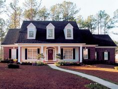 a red brick house with white trim and black roof