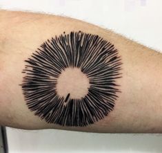 a man's arm with a black circle tattoo on it