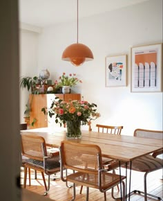 a dining room table with chairs and a potted plant on the top of it