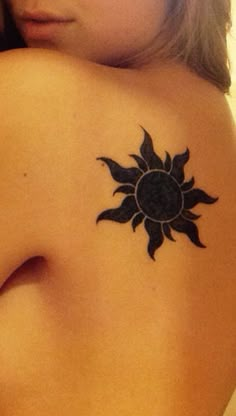 a woman with a sun tattoo on her back