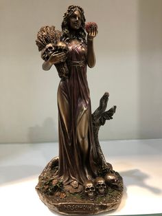 a statue of a woman holding flowers in her hands