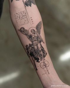 an arm with a tattoo on it that shows the angel holding a cross and compass