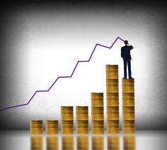 a man standing on top of stacks of coins with an upward graph going up in the background