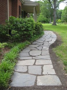 a stone path in front of a brick house