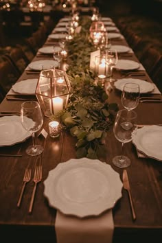 a long table is set with candles and place settings for dinner guests to sit at