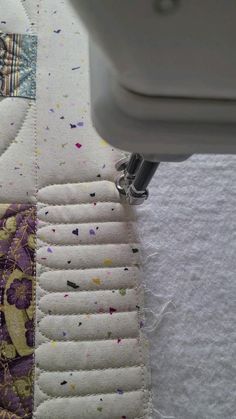 a close up view of a piece of fabric with flowers on it and a sewing machine in the background