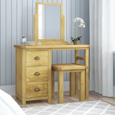 a wooden dressing table with two stools and a mirror