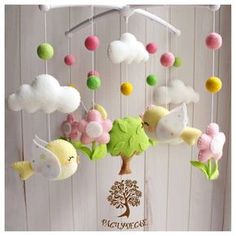 a baby mobile with birds and clouds hanging from it