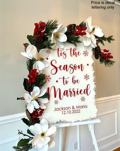 a sign that says tis the season to be married with flowers and pine cones around it