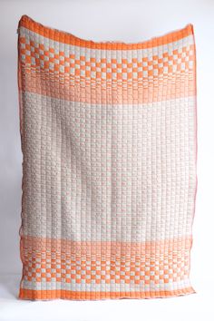 There are only two families in the world who are still practicing this craft. Sujani weaving is a double-cloth technique that creates cotton-filled "puffs" with a wonderfully unique and soft texture. Whether draped over your bed, sofa, or used as a cozy wrap, this blanket is as versatile as it is beautiful. Our quilts are hand-loomed in the home of our artisans in Gujarat, India. Each quilt takes upwards of 14 hours to make. The family is among the last remaining artisans with the knowledge of t Cozy Wrap, Quilted Throw Blanket, October 31, Orange And Pink, Hand Candle, 50th Gifts, Linen Pillows, Hand Loom, Throw Quilt