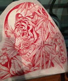 a red and white drawing of a tiger on a piece of paper next to a window