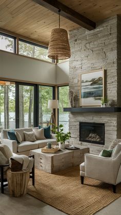 a living room with couches, chairs and a fire place in front of large windows