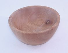 a wooden bowl sitting on top of a white table