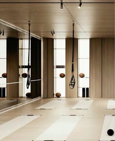 an empty room with yoga mats, mirrors and exercise balls on the floor in front of them