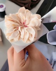 a person is cutting paper with scissors and a flower in it's center on a table