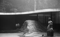 a black and white photo of a statue in front of a building with a fountain