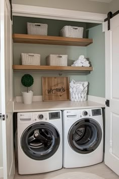 a washer and dryer in a room with open shelving on the wall