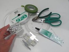 scissors, tape, and other crafting supplies are arranged on a white table top