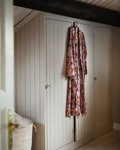 an open closet with two coats hanging on it