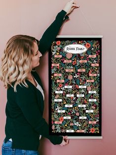 a woman is holding up a poster with flowers on it and the words rose family