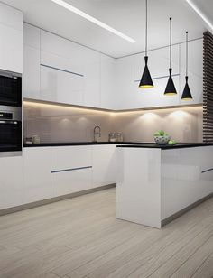 a modern kitchen with white cabinets and black lighting hanging from the ceiling, along with wooden flooring